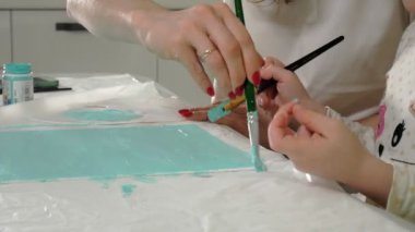 Anne ve çocuk renkli fırça ile boya. Oyunlar çocuklu erken çocukların gelişimini etkiler.