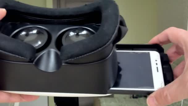 Человек держит шлем виртуальной реальности, вид от первого лица — стоковое видео