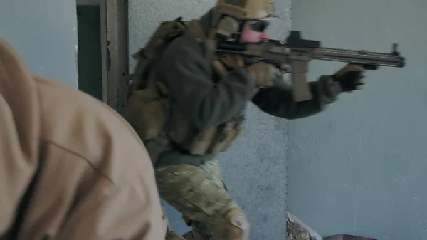 Soldados en camuflaje con armas militares golpean la puerta y hacen la incautación del viejo edificio, el concepto militar —  Fotos de Stock