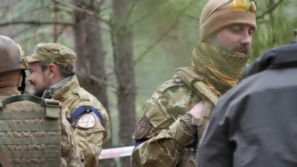 Солдаты в камуфляже готовятся к бою и проверяют снаряжение и оружие — стоковое видео