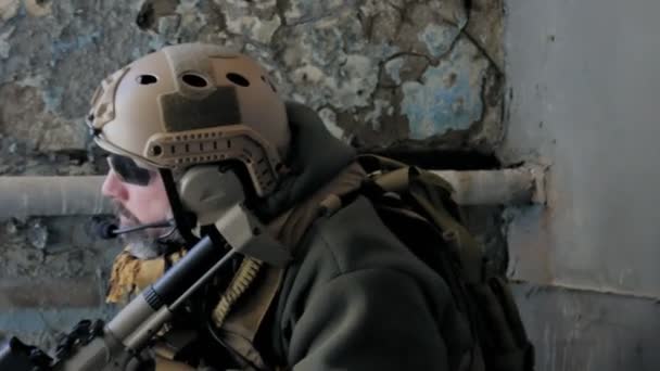 Soldaten in Tarnung mit einer Militärwaffe, die durch das Fenster eines alten Gebäudes auf das Gewehr zielte, das militärische Konzept — Stockvideo