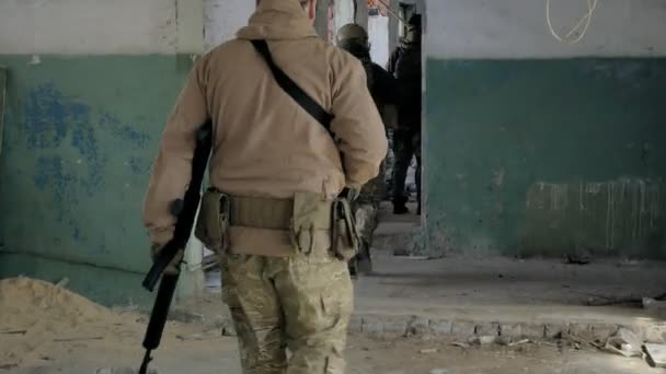Vojáci v kamufláž boj zbraněmi plížit podél chodby staré budovy, vojenský koncept — Stock video