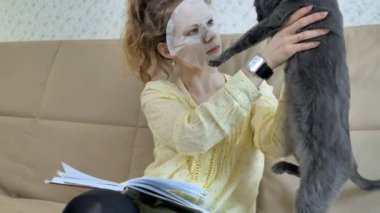 Genç kadının mutfağa Anasayfa kedi yüzüne maske temizlik ile yüz maskesi maskesi yapması