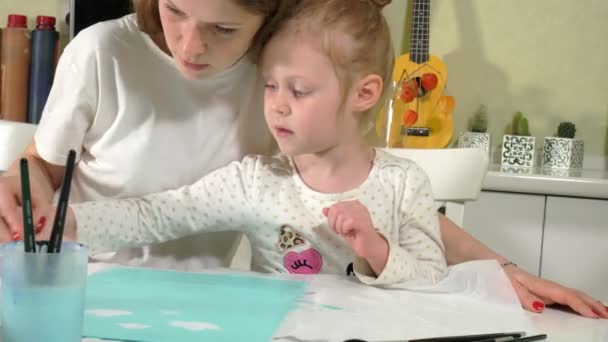 Mother and child paint with colored fingers. Games with children affect the development of early children. — Stock Video