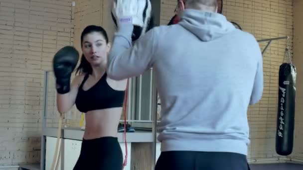 Coach training female boxer on sports studio in gym — Stock Video