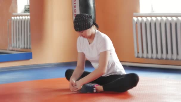 Eine attraktive Frau macht Stretching im Simulator in einer Sporthalle — Stockvideo