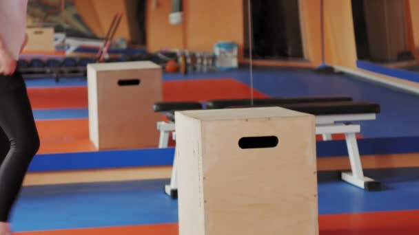 Une femme séduisante fait des étirements sur un simulateur dans une salle de sport — Video