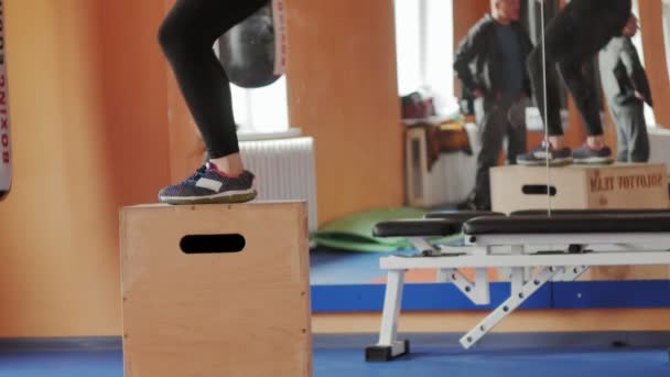 Женщина-кикбоксер тренируется в спортивной студии с гантелями — стоковое видео