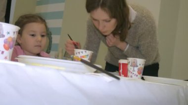 Çocuk erkek ve kız birlikte sınıf ve çizim masasının etrafında oturuyor. Onlarla birlikte onların genç ve güzel bir öğretmendir.