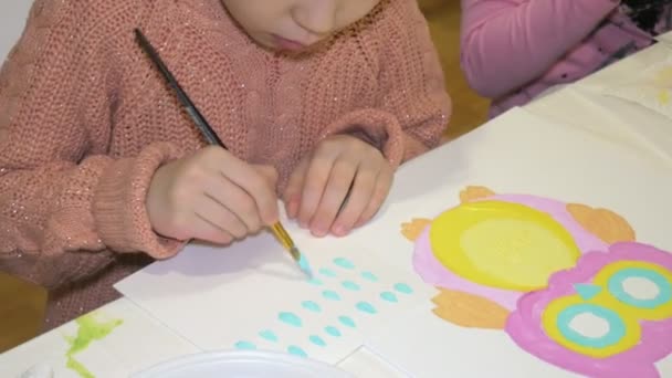 Kinderen-jongens en meisjes zitten samen rond de tafel in de klas en tekening. Met hen is hun jong en mooi leraar. — Stockvideo