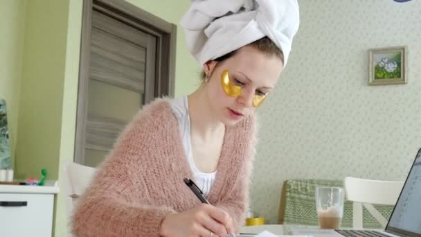 Attractive business woman applying cosmetic facial spots at home, working behind laptop — Stock Video