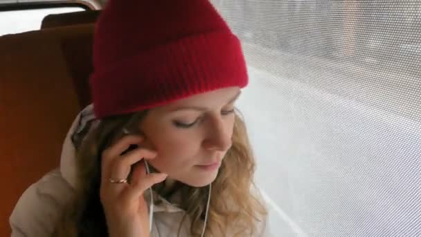 Jeune femme gaie voyageant en bus un jour triste. Elle regarde par la fenêtre — Video