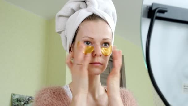 Aantrekkelijke vrouw spplying cosmetische gezichts patches thuis — Stockvideo