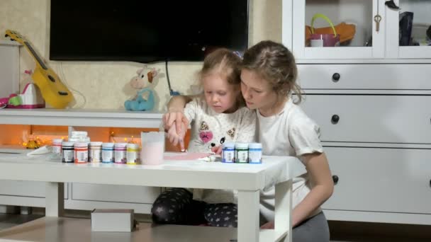 Mother and child paint with colored fingers. Games with children affect the development of early children. — Stock Video