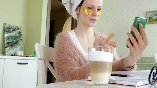 Atractiva mujer de negocios aplicando manchas faciales cosméticas en casa, hablando por teléfono — Vídeos de Stock