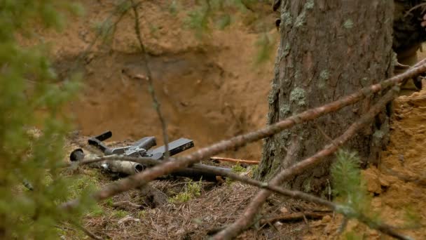 El rifle yace en el suelo en el bosque — Vídeos de Stock