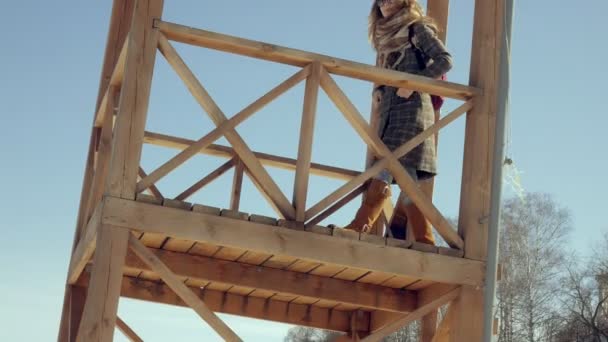 Confident beautiful business woman walking in the A wooden rescue tower on the beach during the absence of sesosis — Stock Video