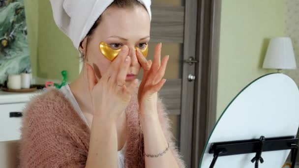 Привлекательная женщина с косметическими нашивками на лице дома — стоковое видео