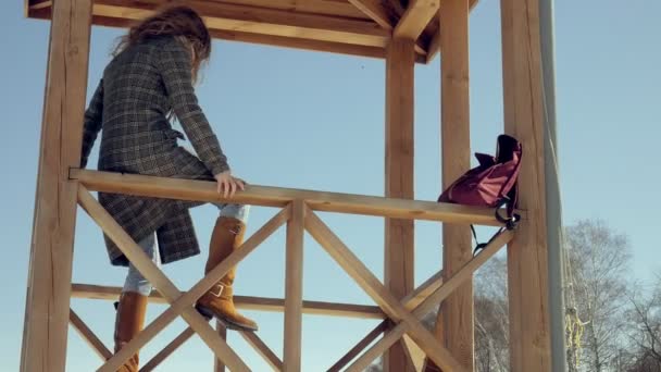 Fiduciosa bella donna d'affari che cammina nella torre di salvataggio in legno sulla spiaggia durante l'assenza di sesosi — Video Stock