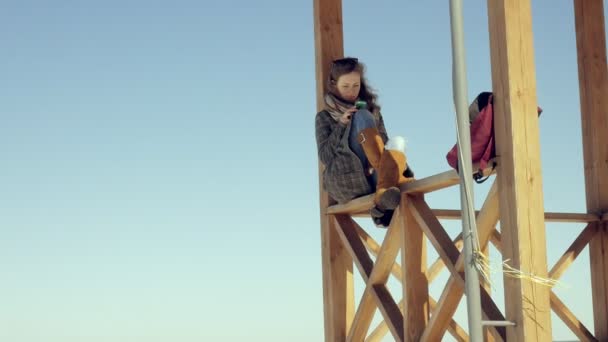 Mulher usando Smartphone Relaxa no banco em Beautiful Park. Jovem mulher em fazer gestos na tela do telefone. Tecnologia ao ar livre — Vídeo de Stock