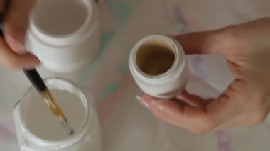 Bir kadın bir ahşap bebek renkli boyalar ile ev stüdyosunda, boyalar Matryoshka boyama, yakın çekim