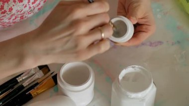 Bir kadın bir ahşap bebek renkli boyalar ile ev stüdyosunda, boyalar Matryoshka boyama, yakın çekim