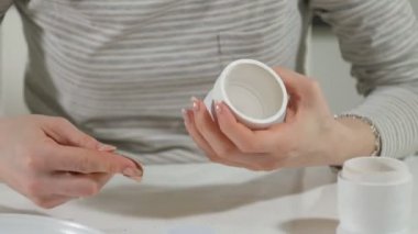 Bir kadın bir ahşap bebek renkli boyalar ile ev stüdyosunda, boyalar Matryoshka boyama, yakın çekim