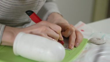 Bir kadın bir ahşap bebek renkli boyalar ile ev stüdyosunda, boyalar Matryoshka boyama, yakın çekim