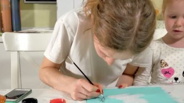 Anne ve çocuk renkli fırça ile boya. Oyunlar çocuklu erken çocukların gelişimini etkiler.