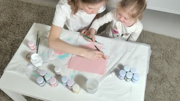 Mother and child paint with colored fingers. Games with children affect the development of early children. — Stock Video