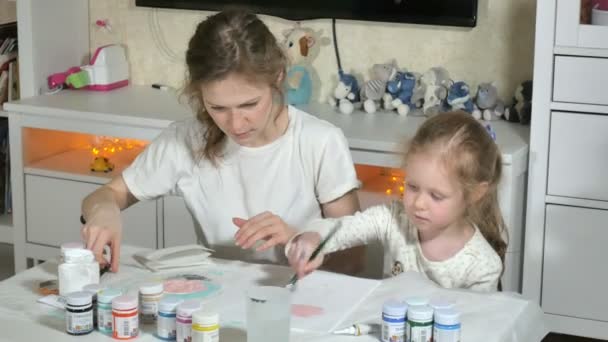 Мати і дитина фарбують кольоровими пальцями. Ігри з дітьми впливають на розвиток дітей раннього віку . — стокове відео