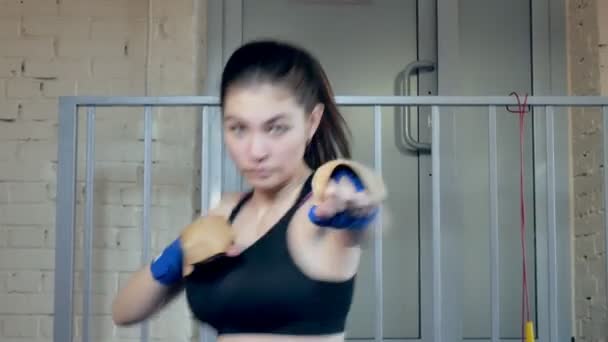 Beautiful kickboxing woman training punching with rubber band in fitness studio fierce strength fit body kickboxer series — Stock Video