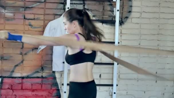 Hermosa mujer kickboxing entrenamiento de perforación con banda de goma en el estudio de fitness fiera fuerza ajuste cuerpo kickboxer serie — Vídeos de Stock