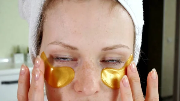 Привлекательная женщина с косметическими нашивками на лице дома — стоковое фото
