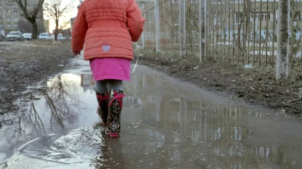 Niña hermosa saltando en charcos después de la lluvia — Foto de Stock