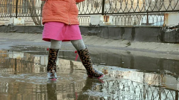 Little beautiful girl jumping on puddles after rain — Stock Photo, Image