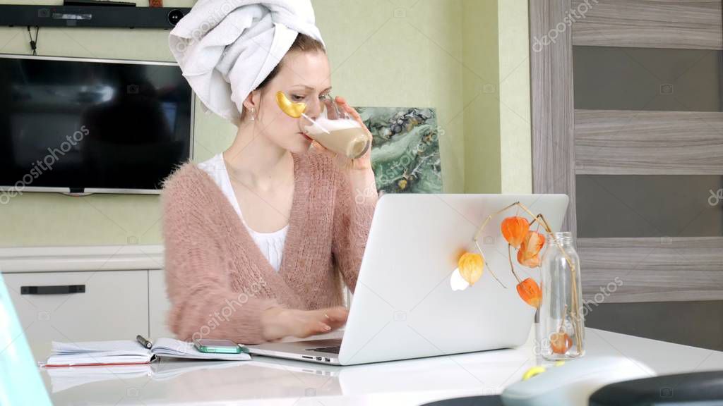 attractive business woman applying cosmetic facial spots at home, working behind laptop