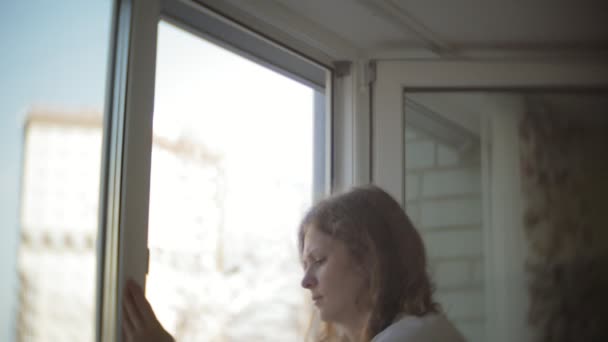 Приваблива дівчина миє вікна вдома. Щоб прибрати будинок . — стокове відео