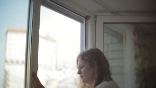 Attraente ragazza lava le finestre a casa. Per ripulire la casa . — Video Stock