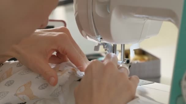 Woman seamstress sewing on a sewing machine — Stockvideo