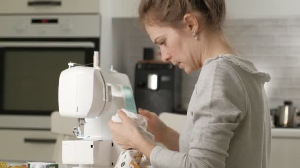 Woman seamstress sewing on a sewing machine — Stockvideo