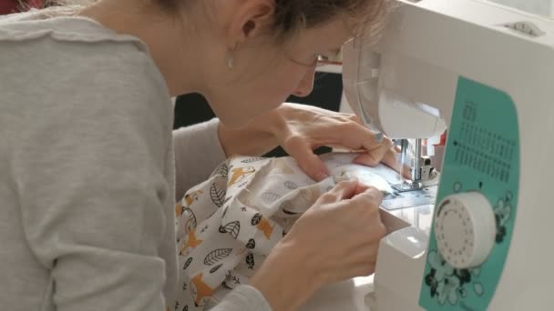 Woman seamstress sewing on a sewing machine — Stockvideo