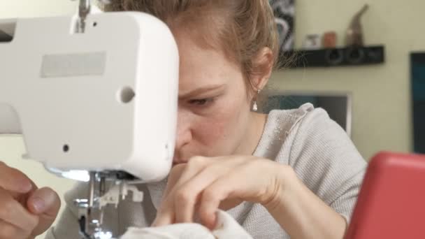 Woman seamstress sewing on a sewing machine — Stockvideo