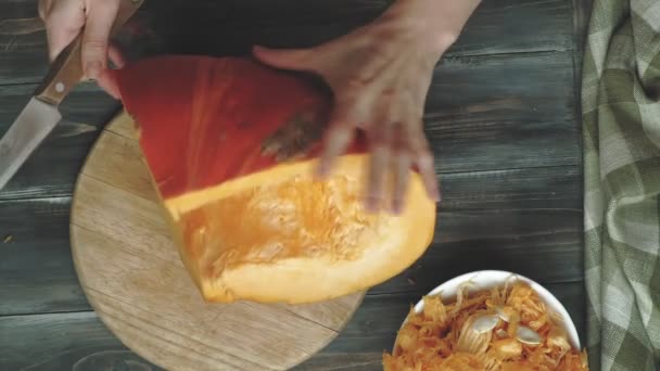 Um homem corta uma abóbora laranja . — Vídeo de Stock