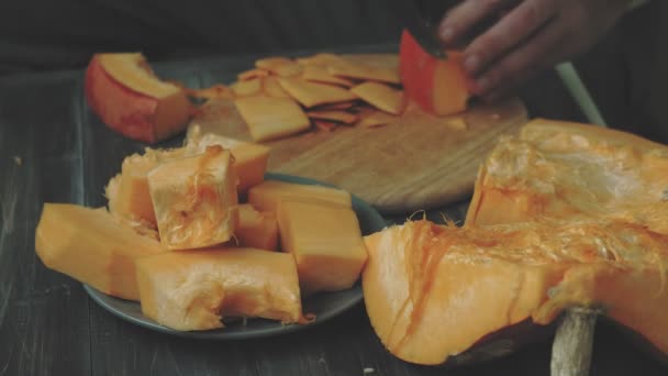 Un homme coupe une citrouille orange . — Video