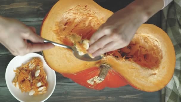 A man cuts an orange pumpkin. — Stock Video