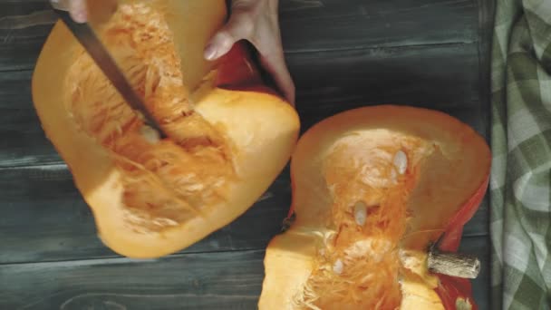 A man cuts an orange pumpkin. — Stock Video