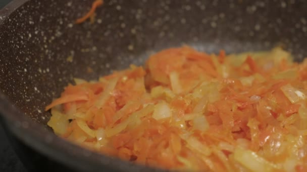 Τηγανίζω λαχανικά σε ένα τηγάνι. Κοντινό πλάνο — Αρχείο Βίντεο
