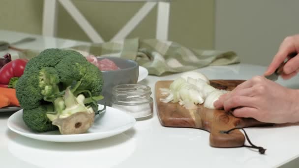 Cortar cebollas frescas en una tabla de madera en la cocina casera — Vídeo de stock