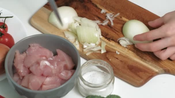 Affettare cipolle fresche su una tavola di legno a casa cucina — Video Stock
